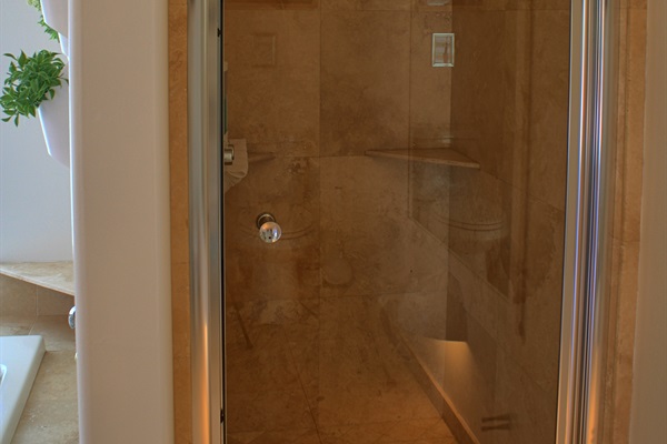 Stand up travertine stone shower in master bathroom