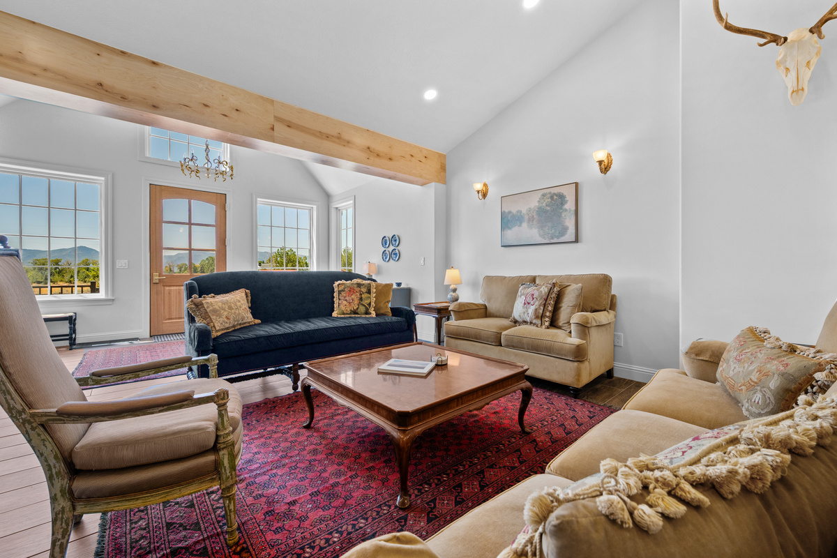 The expansive living room features generous seating, warm wood accents, and an open design created for relaxing and gathering in comfort.