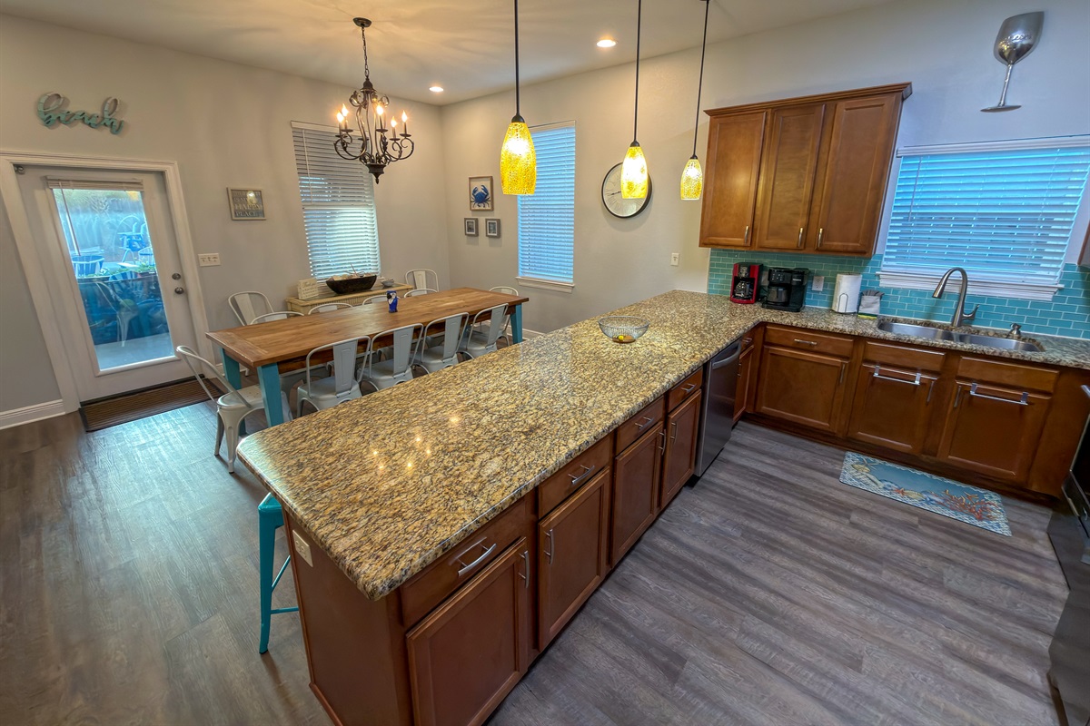Brilliant pendant lighting, rich cabinetry, and thoughtful design details elevate the heart of the home.