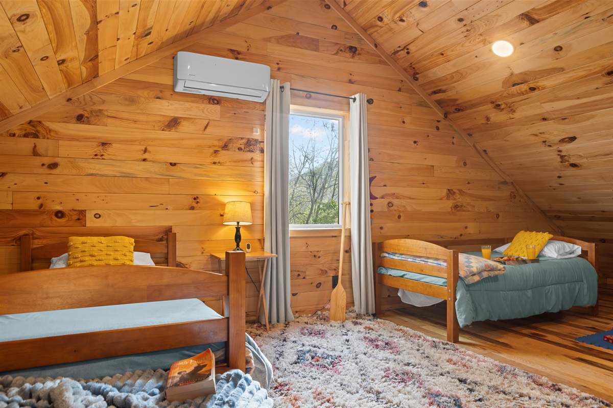 Loft Bedroom 4: Bright space featuring wood accents, playful decor, and a view for fun-filled mornings!