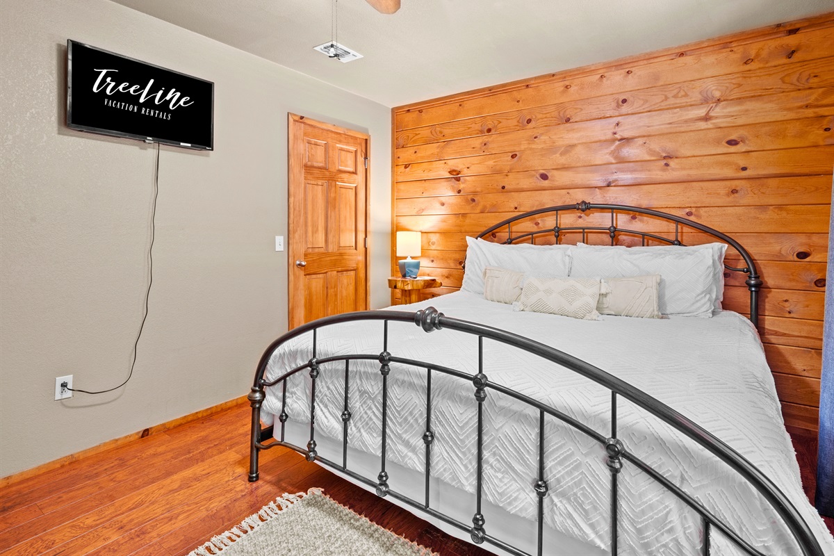 Smart TV included in this bright and airy queen bedroom.