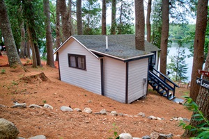 Right side of the cabin with stairs and lake in the background