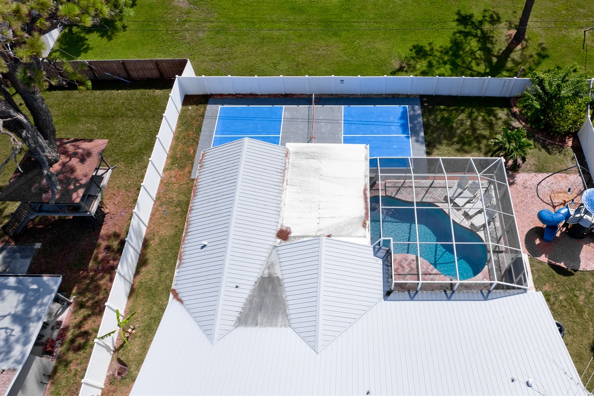 From above, see it all — the inviting pool, the playful backyard setup, and the pickleball court ready for friendly matches. This aerial view captures just how much space and fun your stay has to offer!