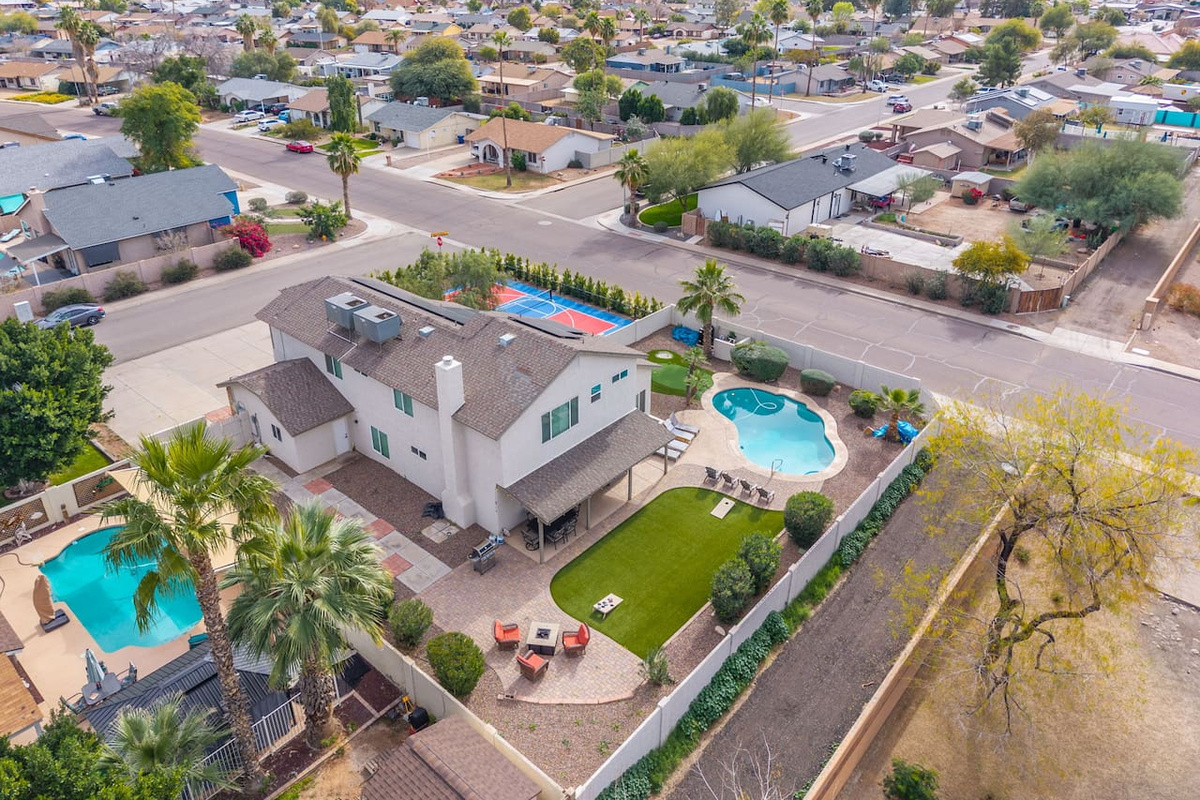 Modern home with resort pool, sports court, and sleek contemporary design in prime neighborhood location.