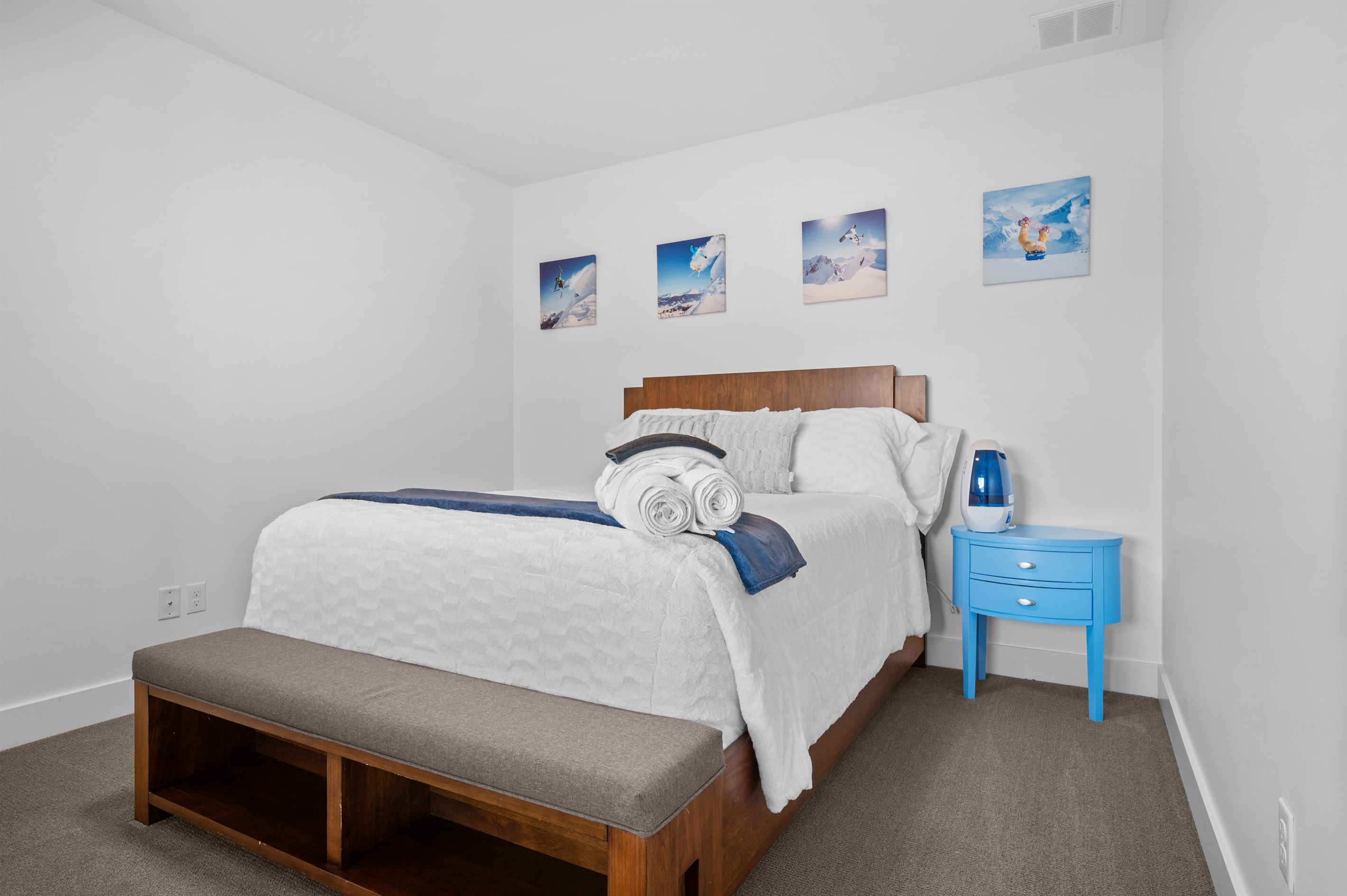 Lower-level queen bedroom with modern décor and soft, inviting tones.
