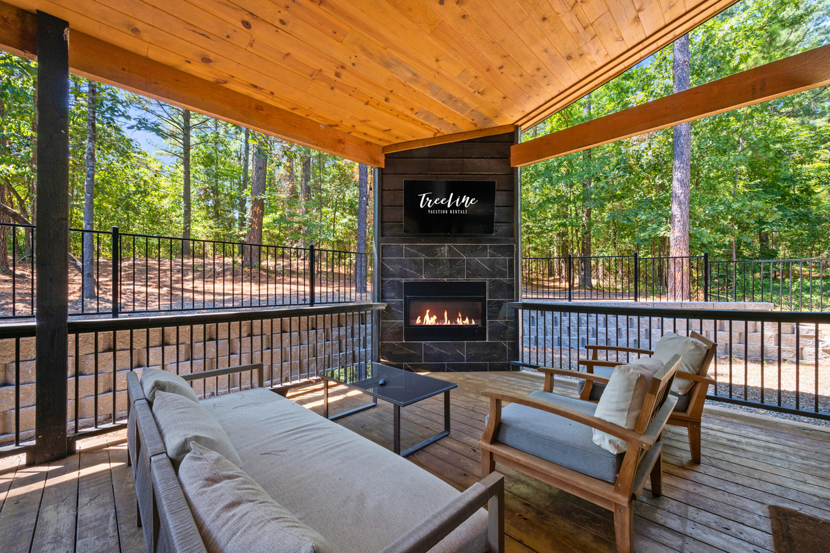 Cozy up around the outdoor fireplace with comfortable seating nearby, creating an inviting gathering spot for conversation, drinks, or simply enjoying the fresh air.