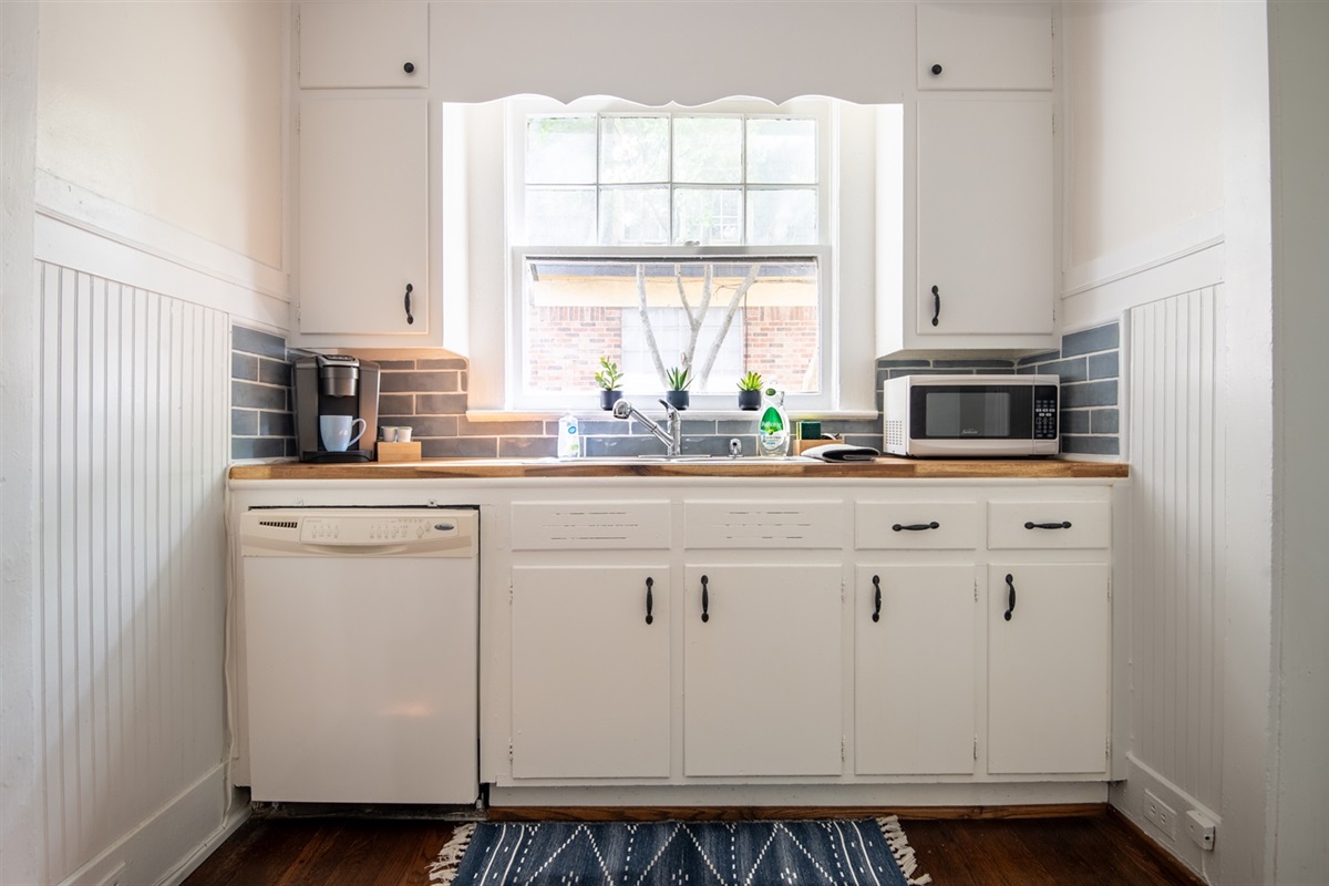 Sunny kitchen with coffee maker, toaster, and microwave to start your mornings right.
