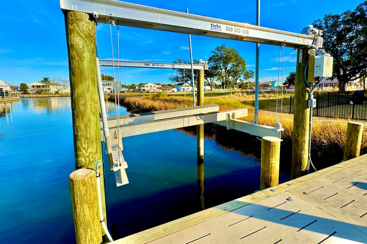 Private backyard dock with boat lift and fillet table, fenced-in backyard, fire pit with Adirondack chairs, hammocks, propane grill, picnic table, outdoor shower, expansive waterfront back deck with table and seating, neighborhood boat ramp and dock