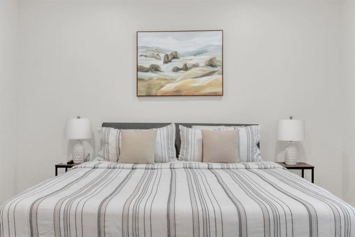 Master suite with neutral tones and stylish framed art.