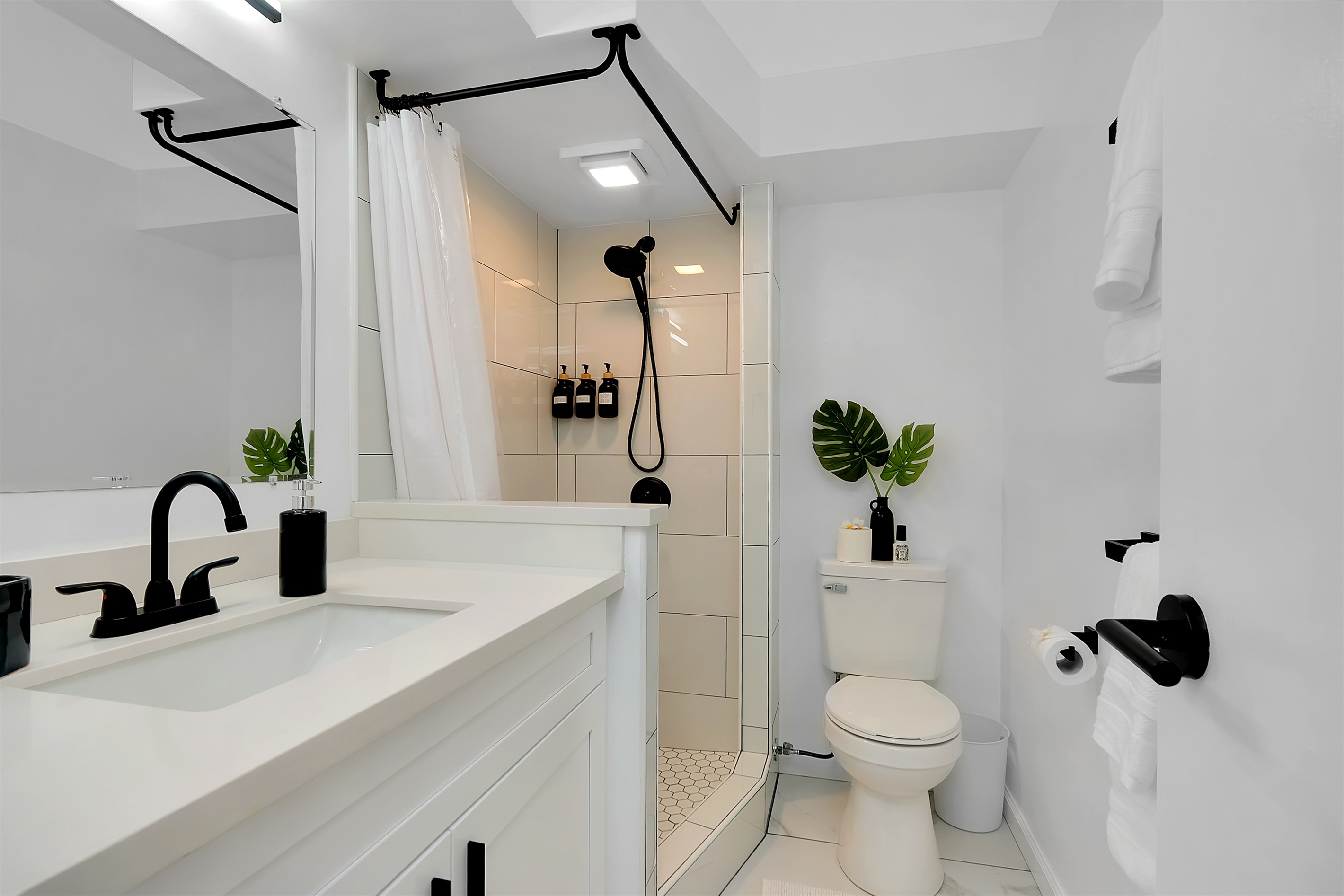 Refresh in style — this beautifully renovated bathroom showcases a modern walk-in shower, elegant matte black fixtures, and tropical greenery accents. Designed with a clean, resort-inspired feel that blends comfort and sophistication in the heart of Waikīk