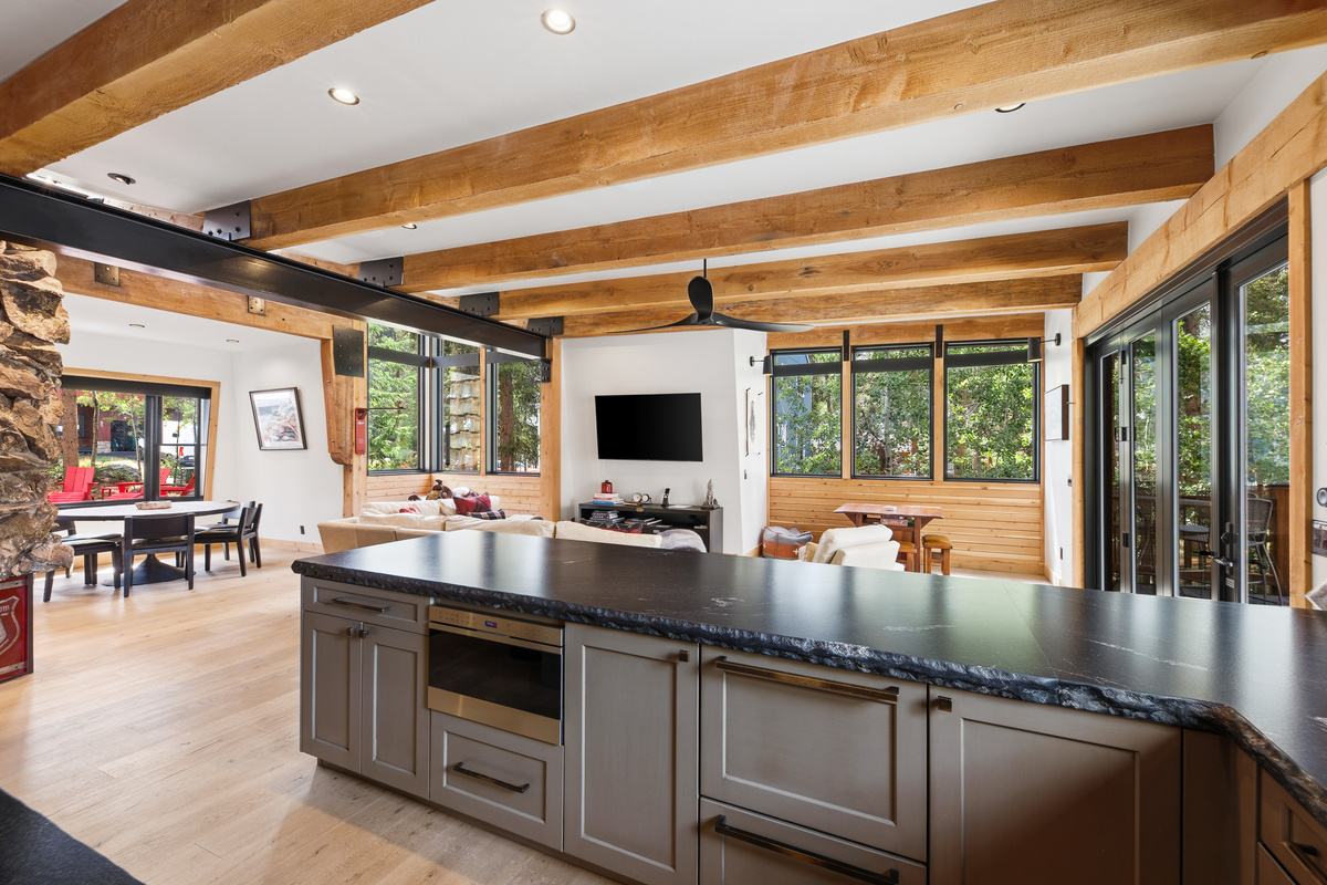 Kitchen with dining area on left in background and living area in center background