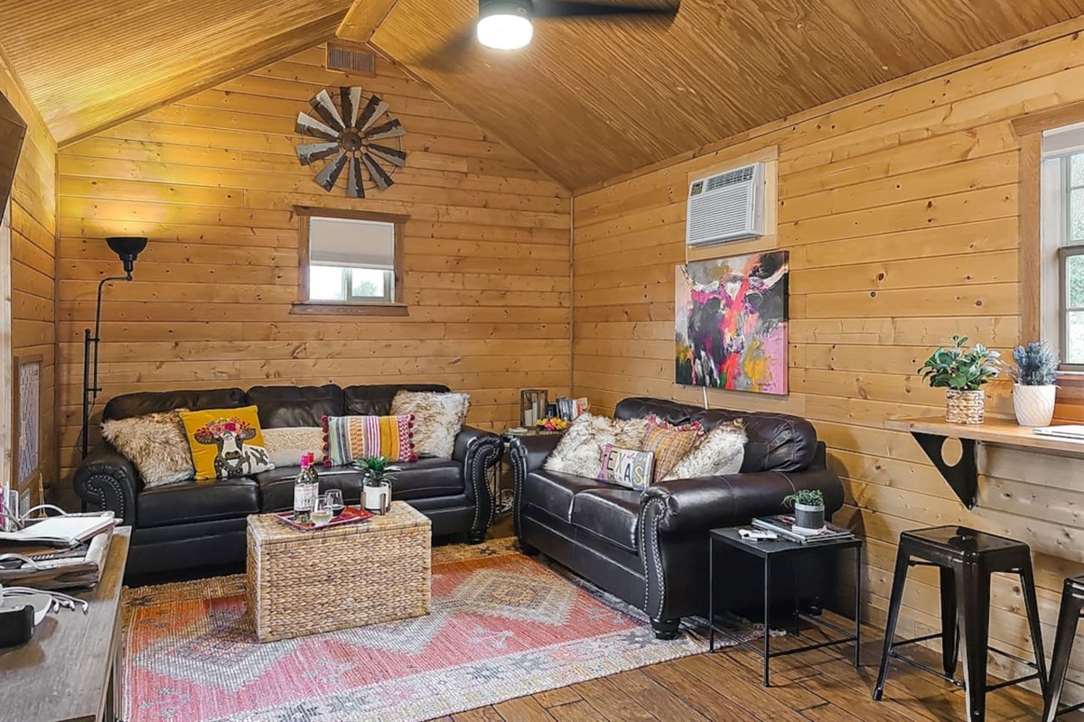 This cozy living area offers the perfect blend of rustic charm and comfort. Relax on plush leather sofas, surrounded by warm wood accents and Texas-inspired decor, making it an inviting space to unwind after a day exploring the Hill Country.