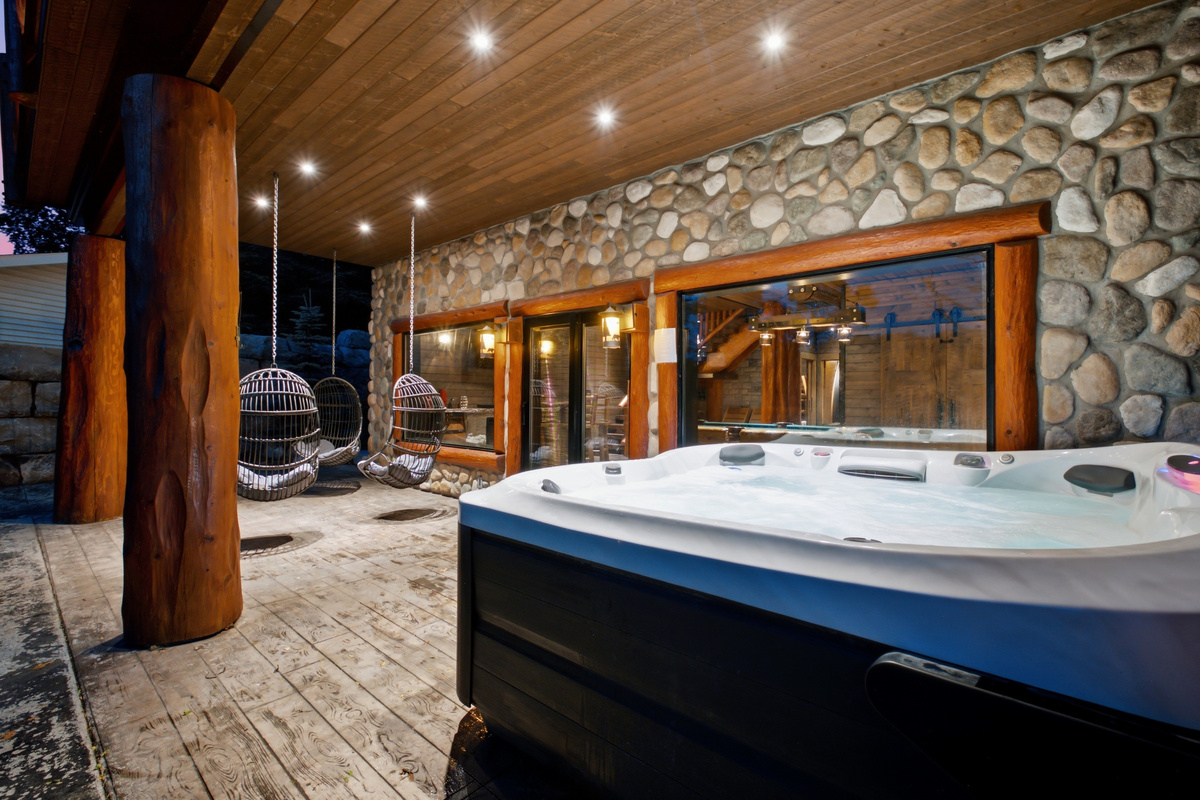 Private hot tub area with stone wall and covered outdoor space