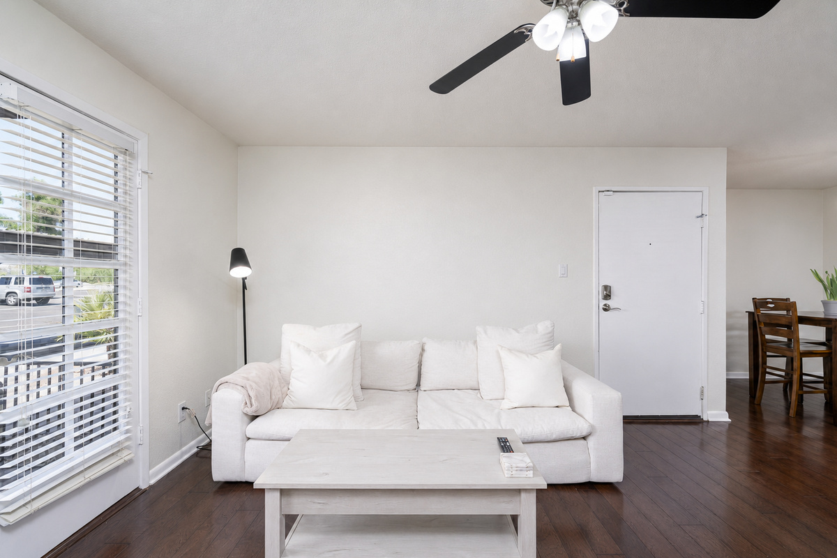 Open in-unit living area with sofa seating, Smart TV, ceiling fan, and easy flow to the dining space