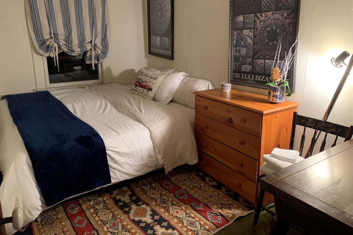 Bedroom 5 on the 3rd floor with queen size bed and a desk. 