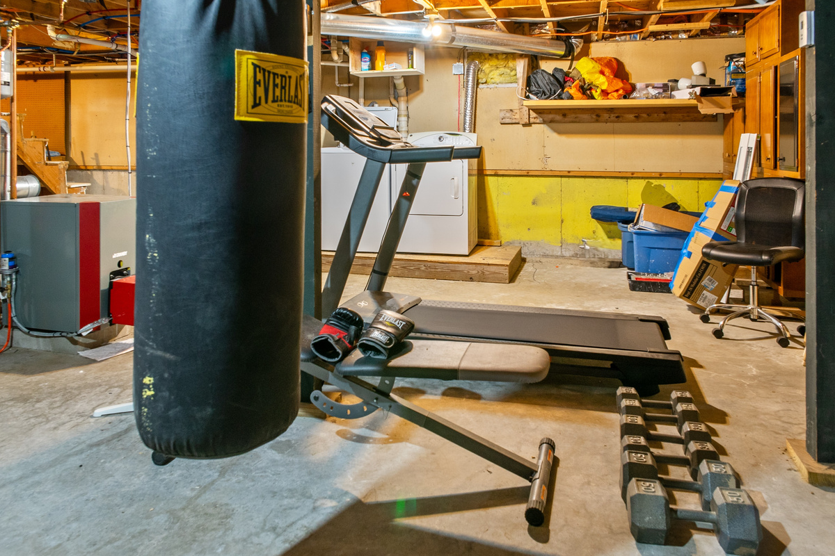 Maintain your workout routine using the basement fitness gear. This dedicated space features an Everlast heavy punching bag, a motorized treadmill, an adjustable weight bench with boxing gloves, and pairs of hexagonal dumbbells for guest use.