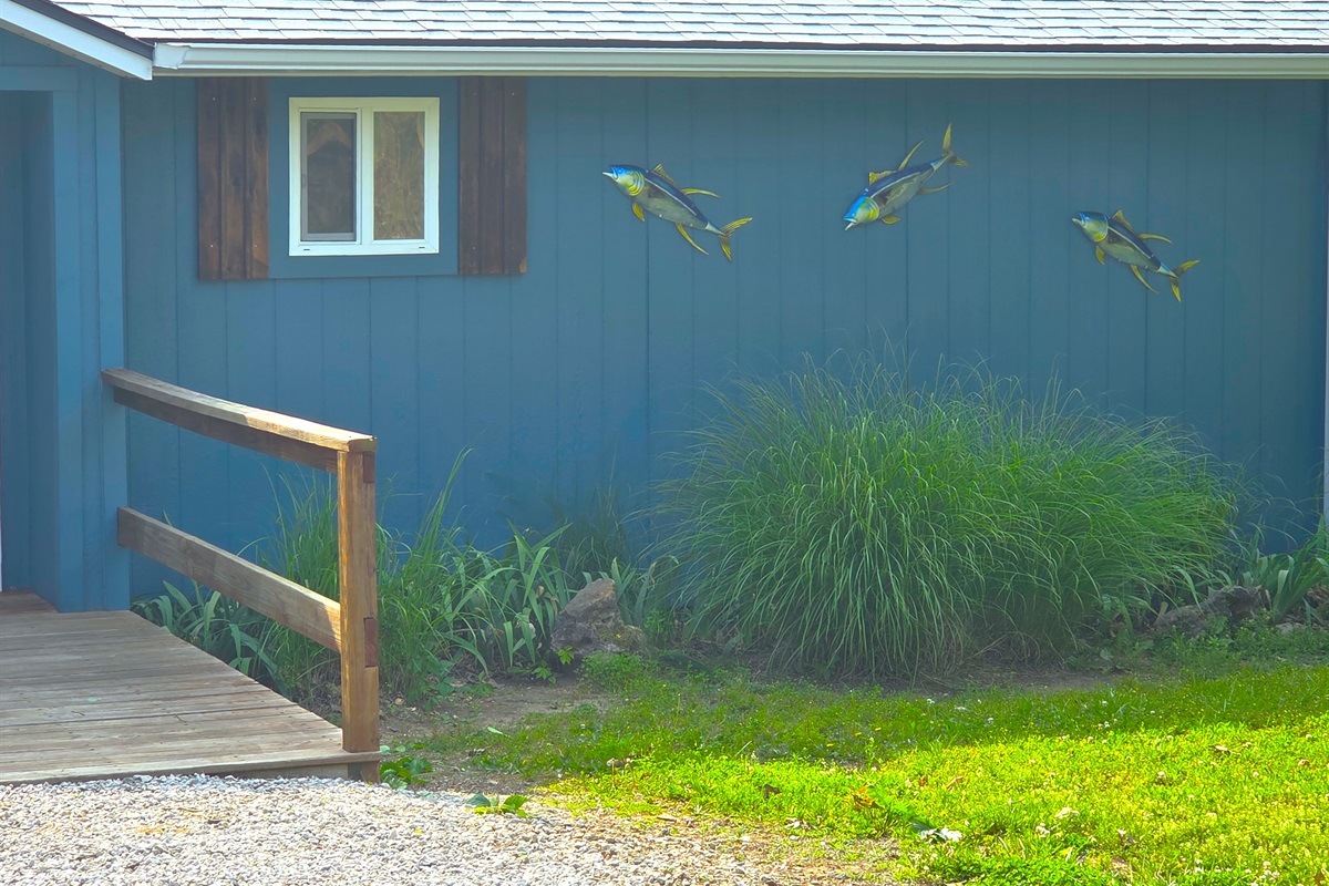 Enjoy the beautiful landscaping with flowers, grass plants, and of course, the fish overseeing it all!