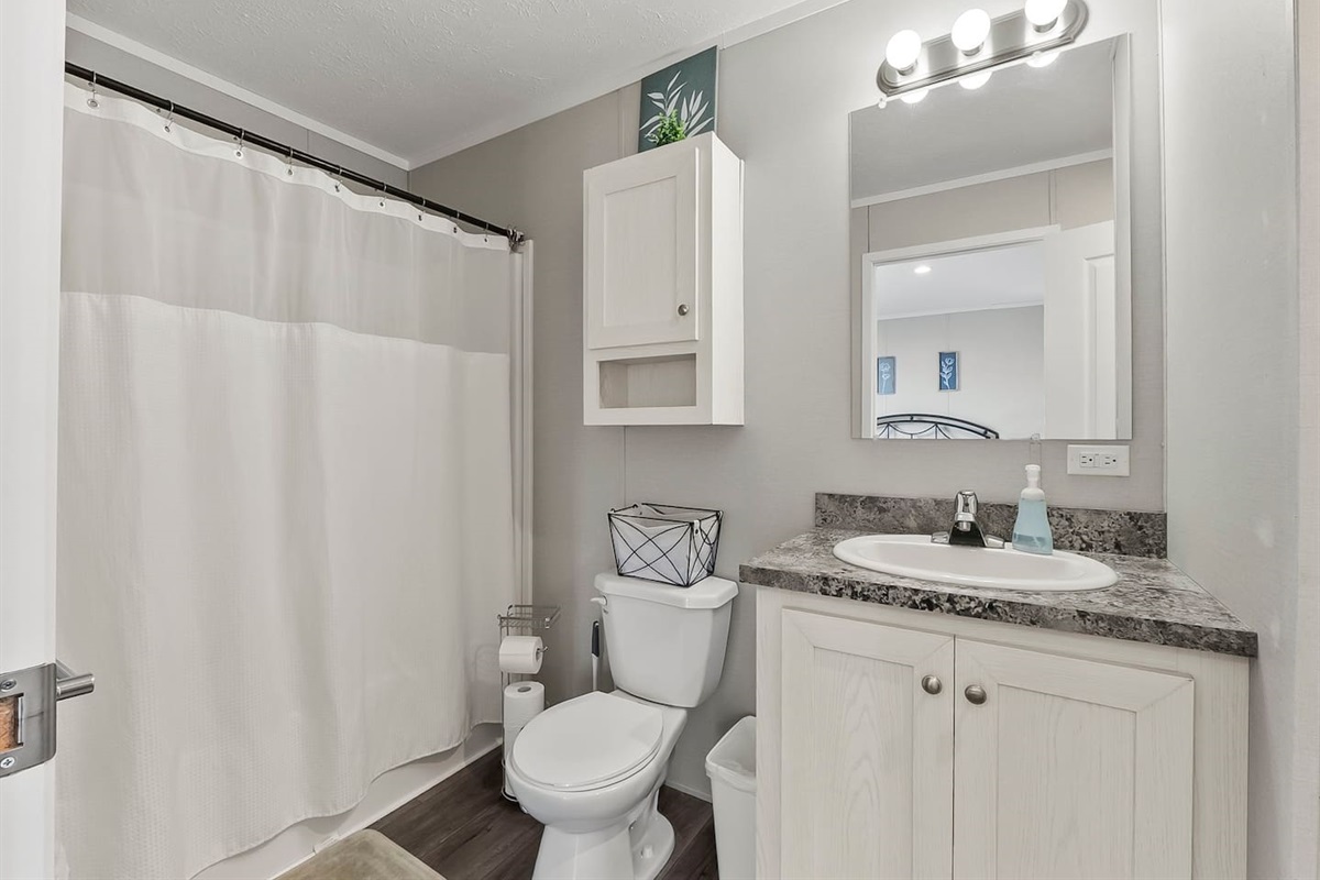 Full bathroom with shower-tub combo, clean finishes, and a bright vanity—everything you need for a comfortable stay.