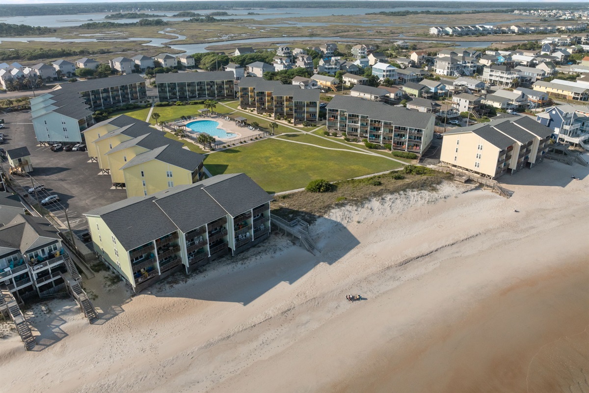 Aerial view of Surf Condos showcasing beachfront buildings and community pool