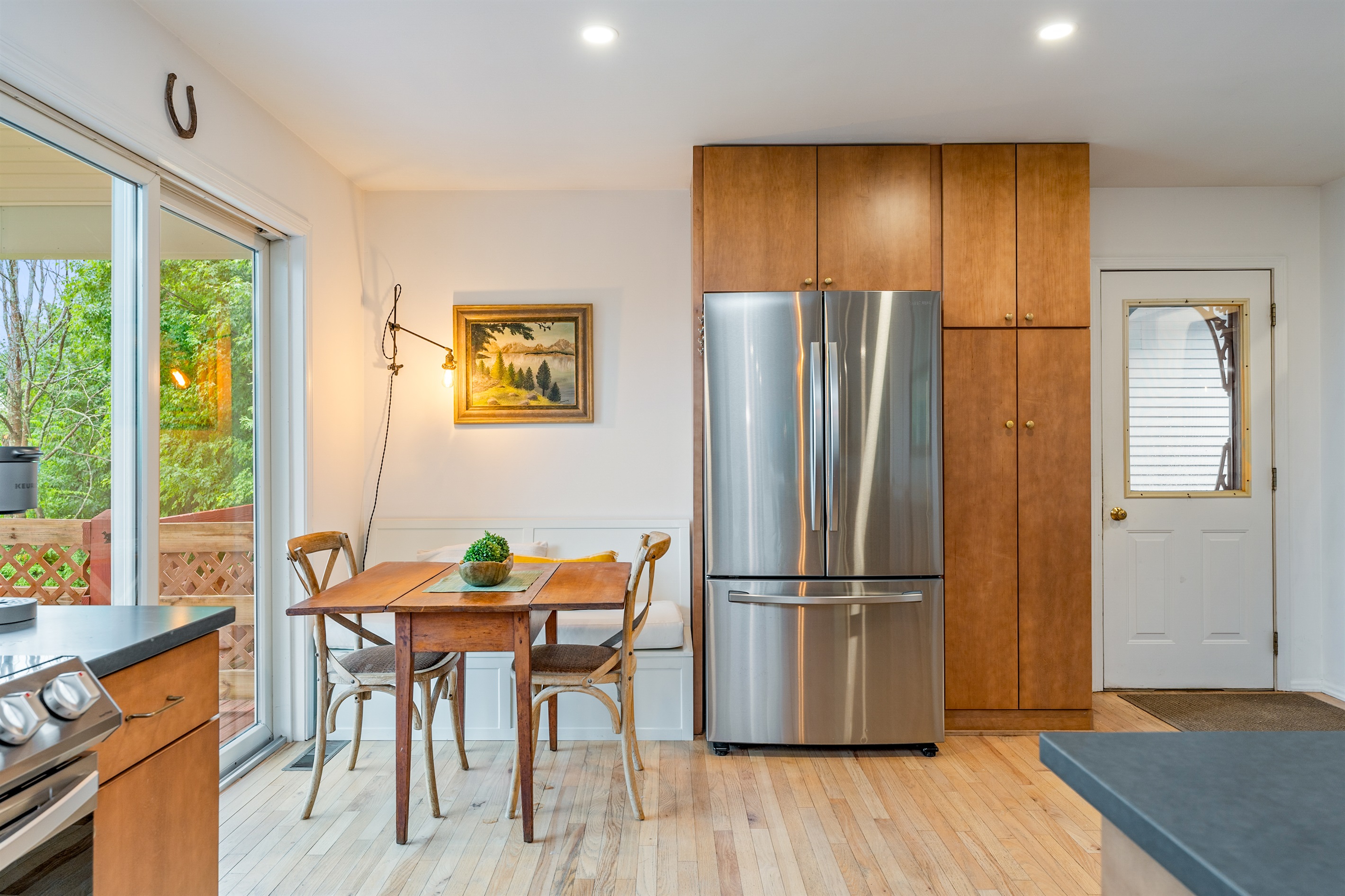 Start your day at this cozy dining nook with natural light, peaceful views, and direct access to the deck for indoor-outdoor living