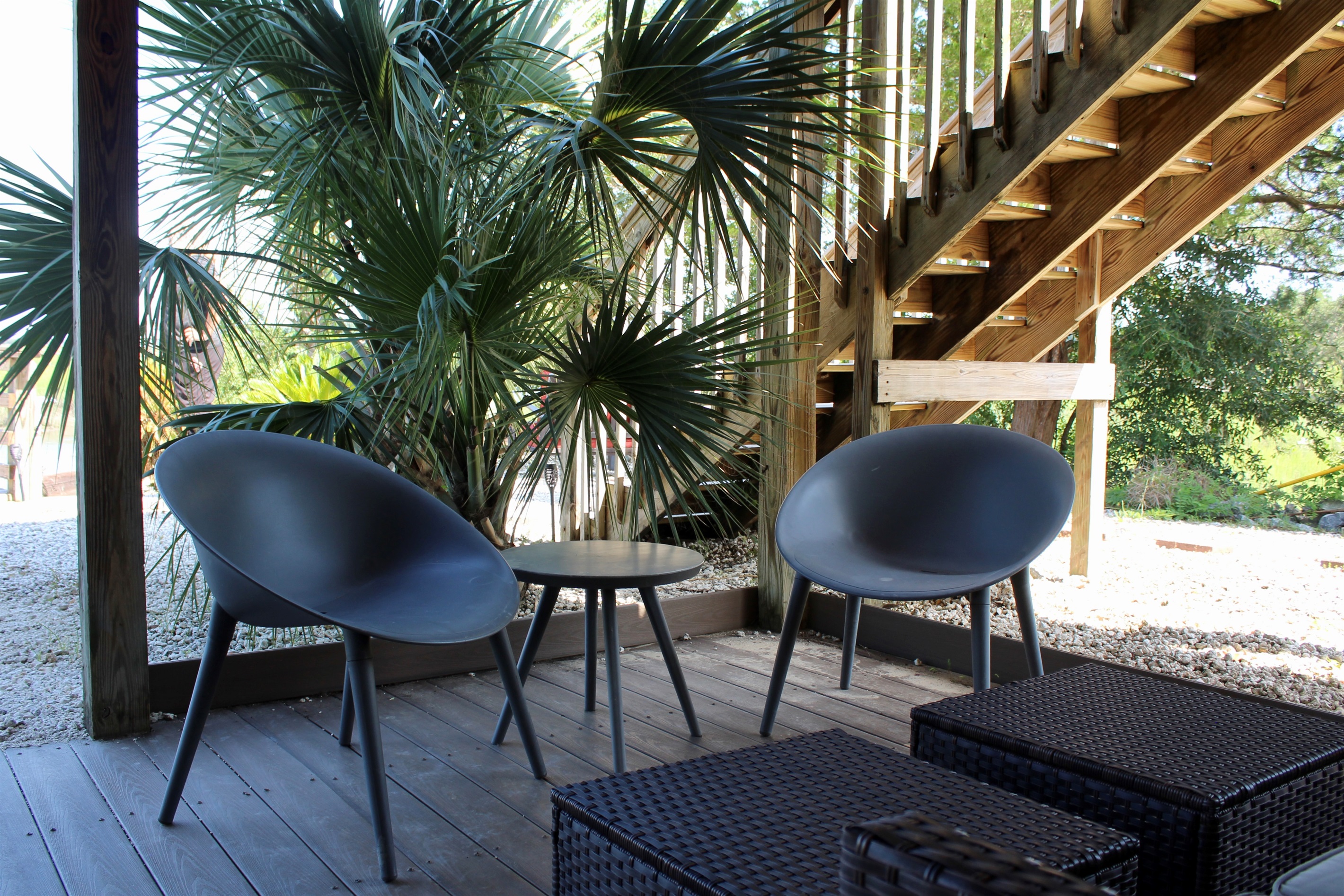 Extra outdoor living space, tucked under the home and surrounded by palms—ideal for relaxing after a day on the water.