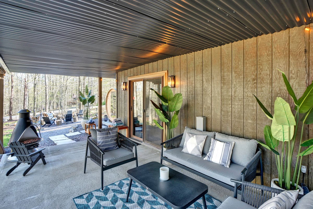 “Covered deck with fire pit and seating — all-weather relaxation.”
