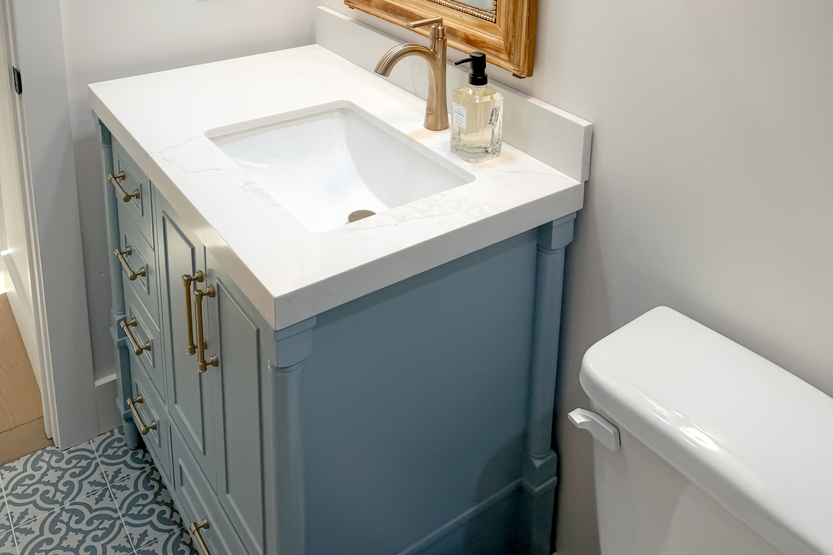Stylish guest bathroom featuring blue subway tiles, a rainfall shower, and vintage-inspired finishes.
