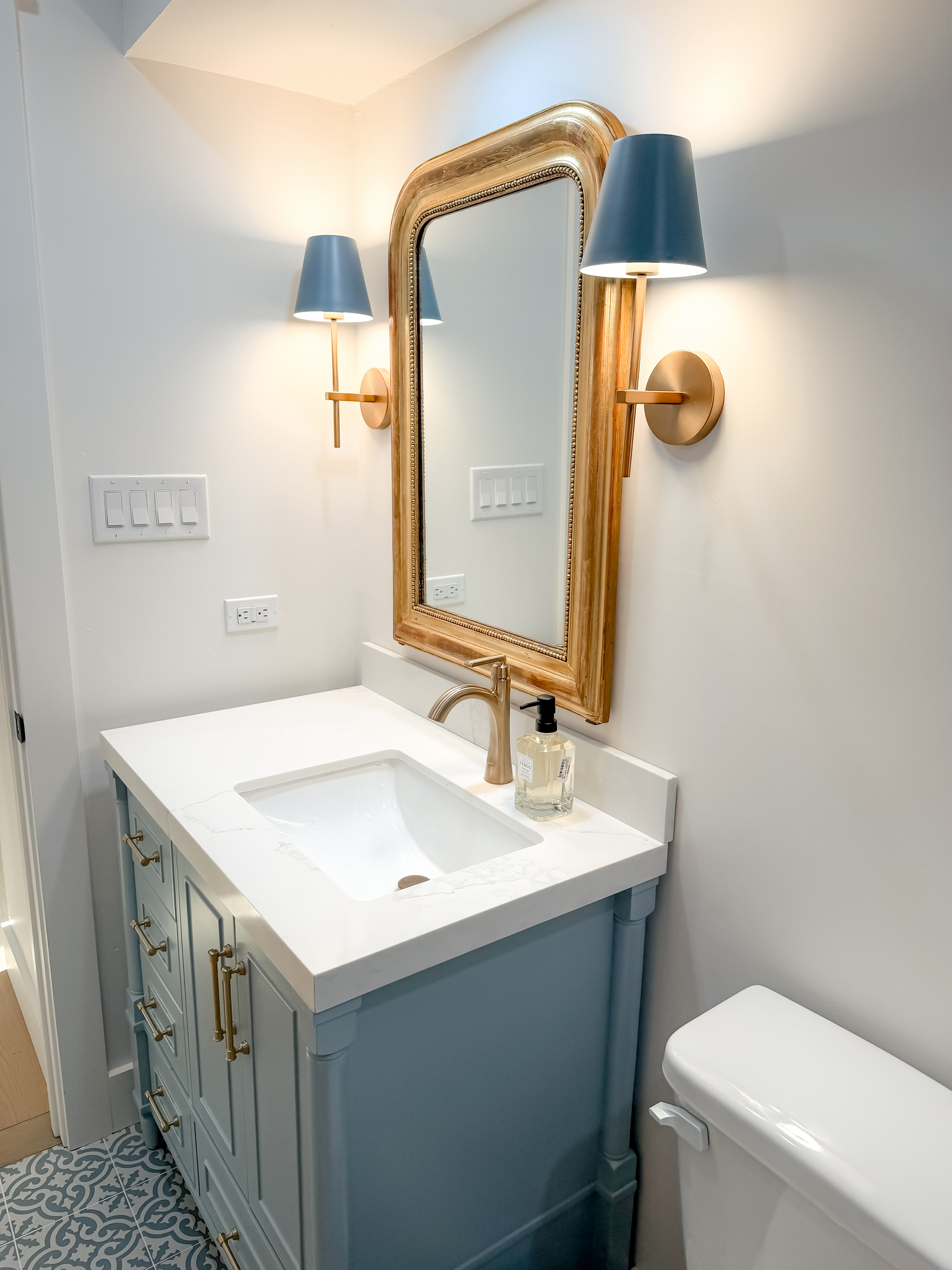 Stylish guest bathroom featuring blue subway tiles, a rainfall shower, and vintage-inspired finishes.