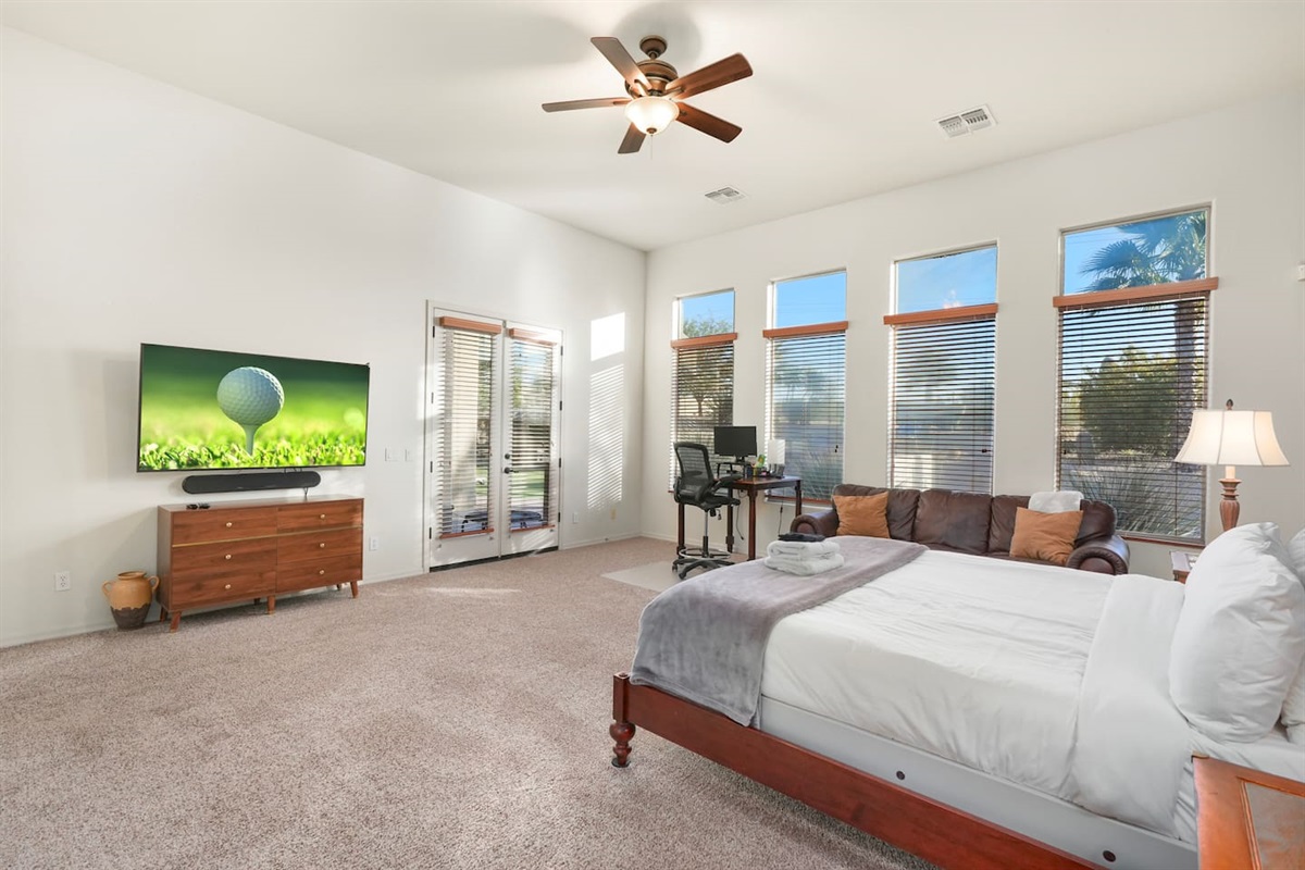 Spacious primary suite with king bed, Smart TV, and abundant natural light