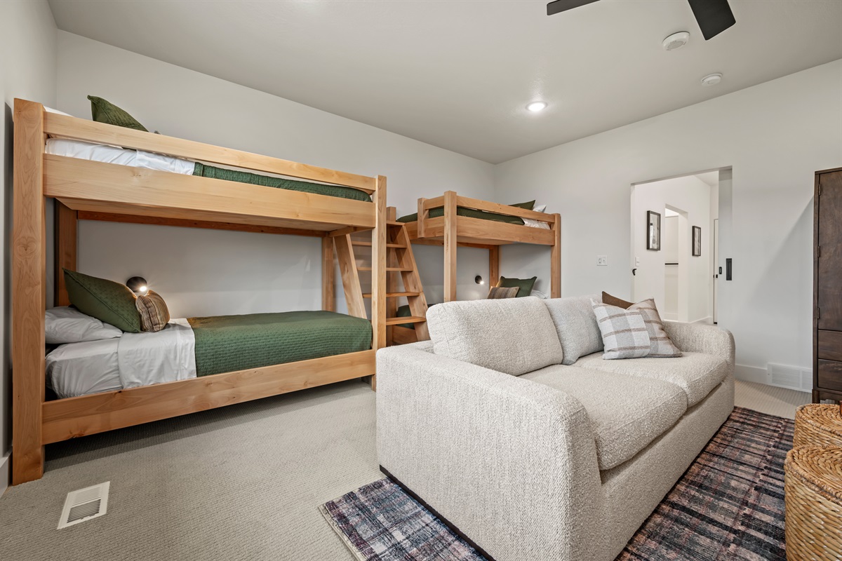 This room offers plenty of sleeping space with two twin-over-twin bunk beds, plus a comfy sofa for lounging.