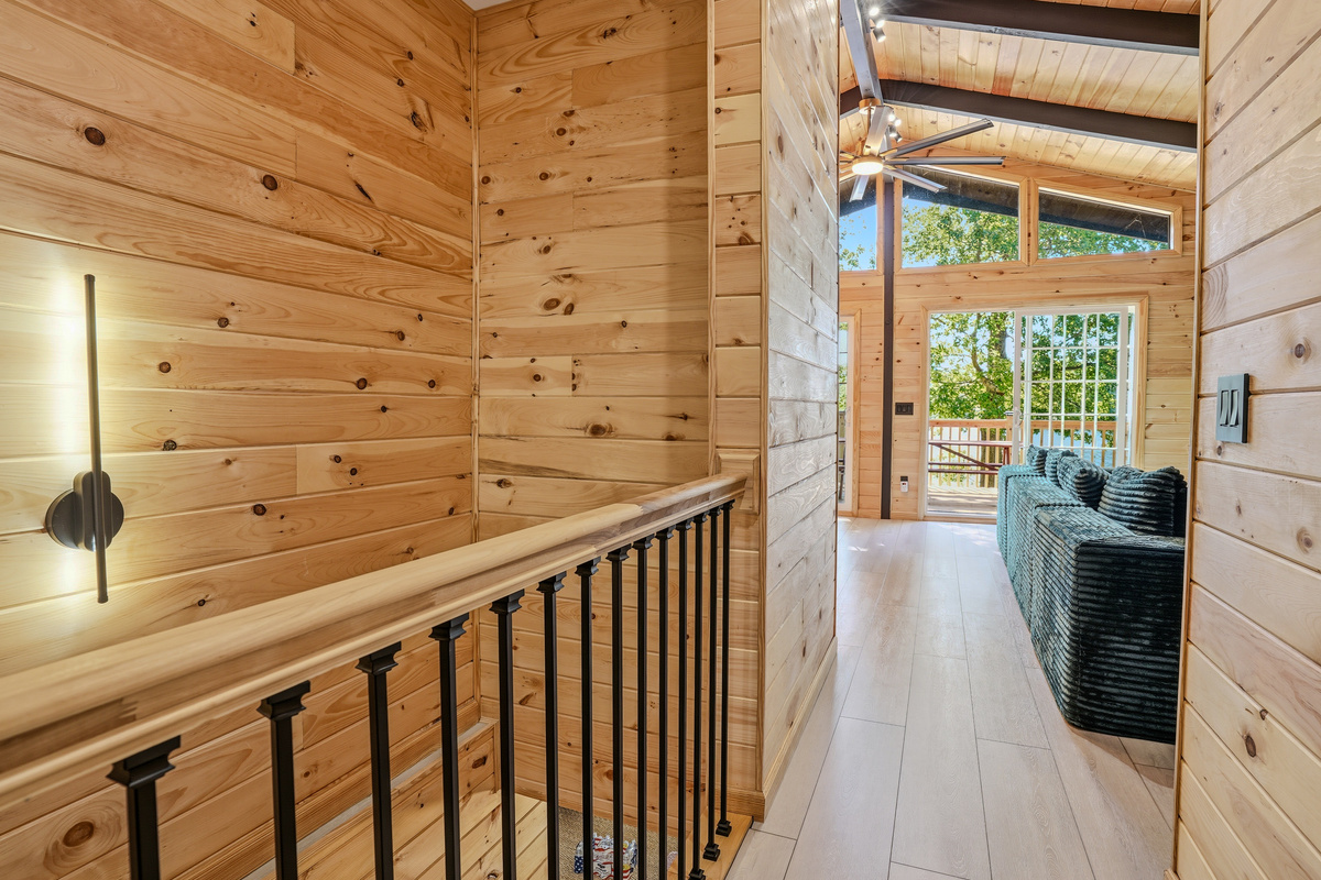 Upper-level landing with open staircase and sightline down to the main living area