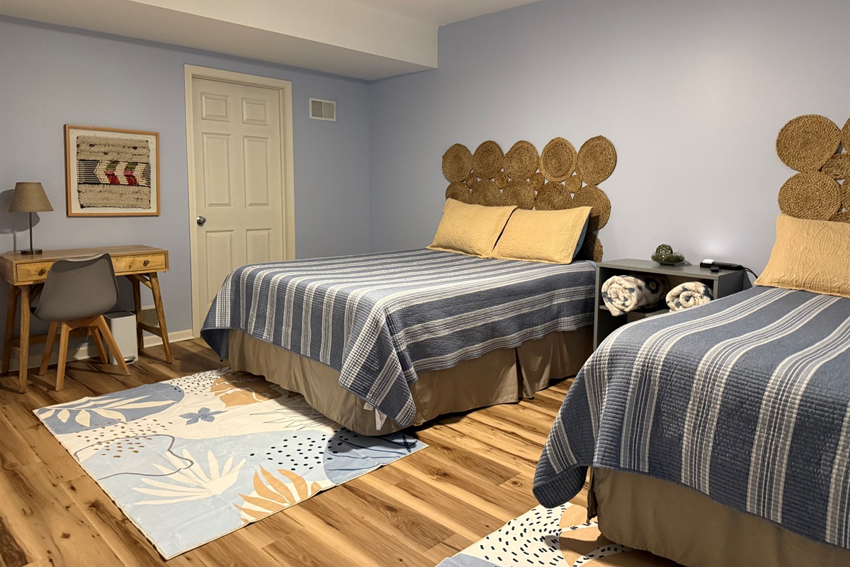 Walkout level bedroom features two queen beds, work desk and smart television.