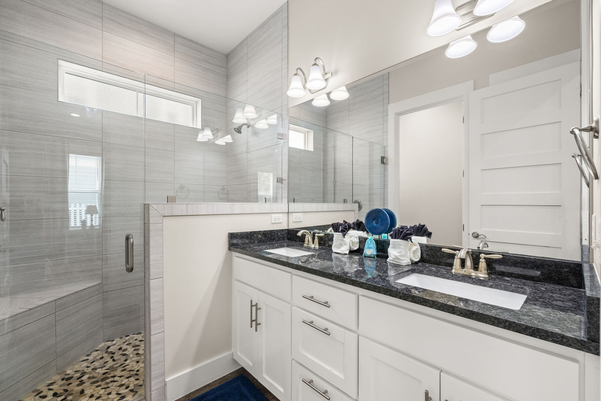Private first-floor ensuite bathroom with walk-in tile shower and dual vanity