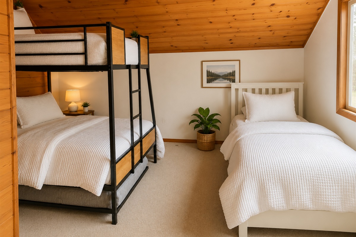 Spacious family-friendly bedroom with a queen bed, two twin beds, two extra twin mattress, and a crib— perfect for groups traveling with kids.