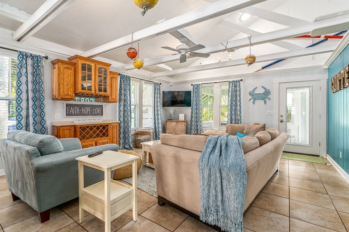Living room, with access to screened front porch which has table with 6 chairs, coach and chair. 