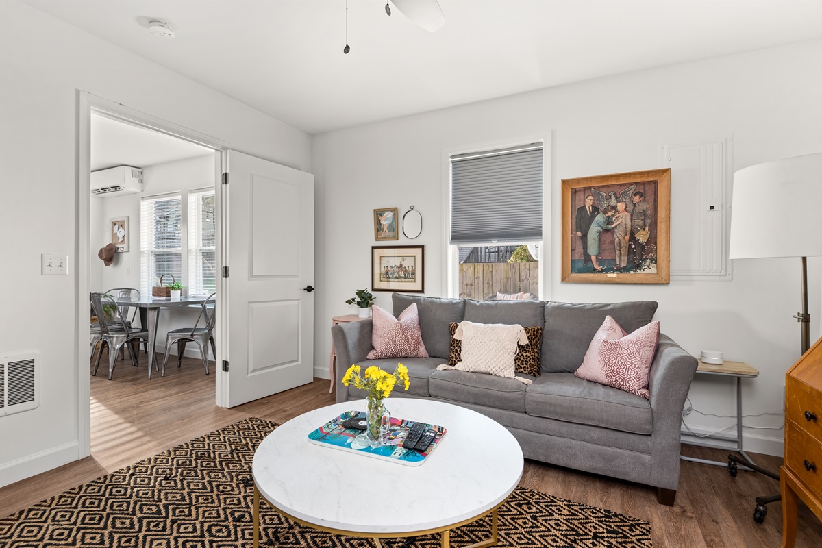 Spacious living area with sofa, TV & desk space.