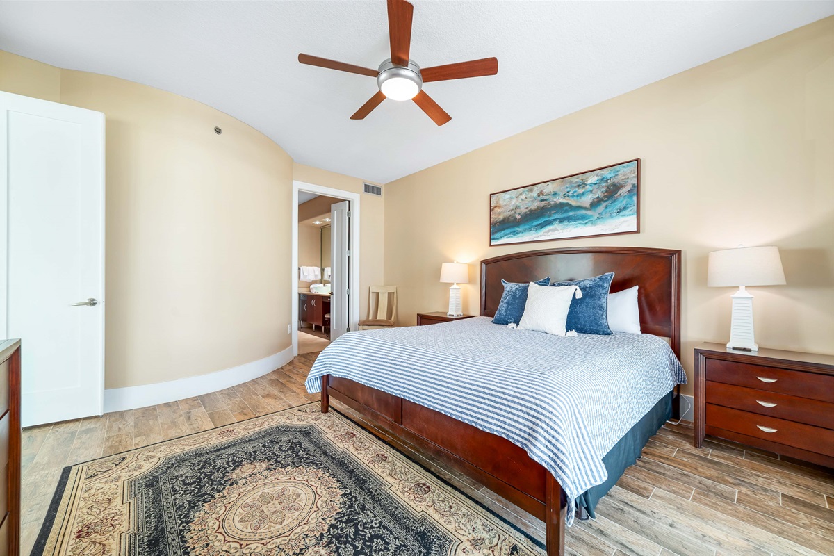 Bright and inviting primary bedroom featuring a comfortable king-size bed with colorful accents and ample storage. A perfect space to relax and recharge.