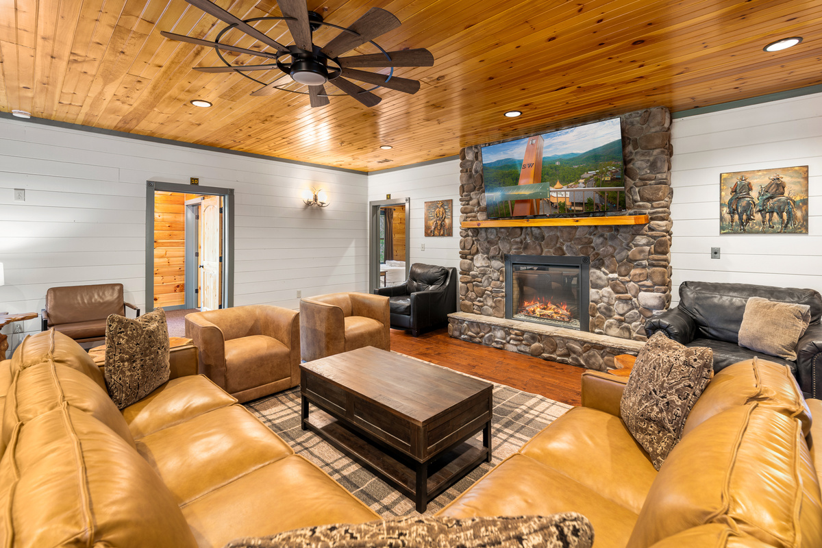 A 75" TV, roaring fireplace, and oversized Italian leather sectional anchor the main living room — with multiple separate hangout zones so the full group never feels crowded into one corner. Two pull-out beds.