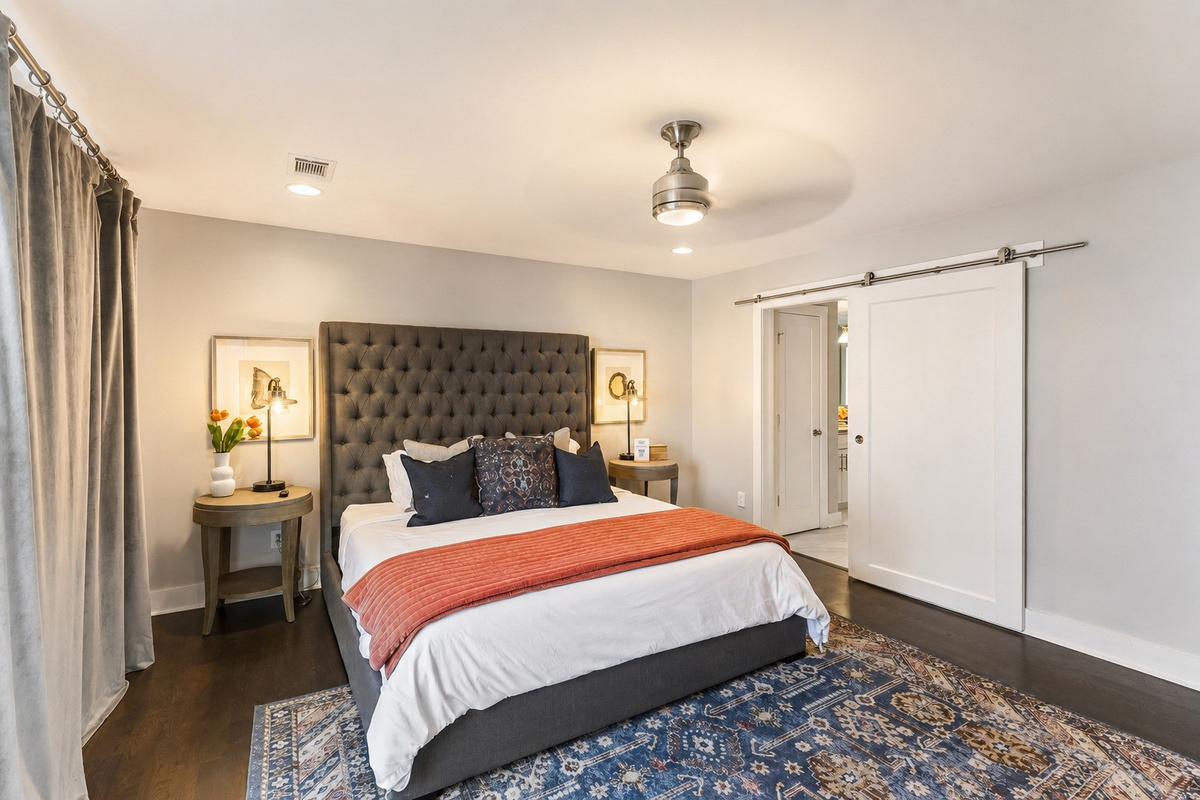 Wake up in the master suite &mdash; king bed with a charcoal tufted headboard, barn door, and private balcony doors to greet the morning.