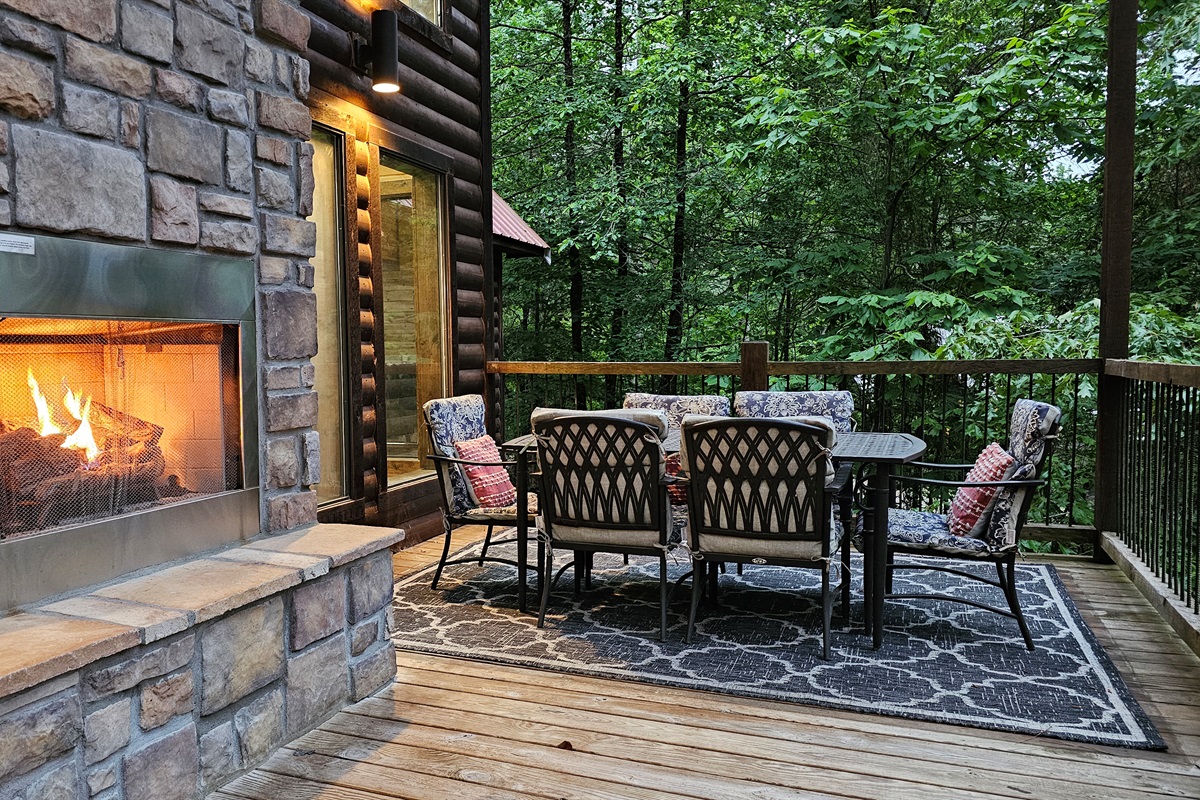 Outdoor Lounge: Unwind by the stone fireplace amidst nature's beauty on the spacious deck!