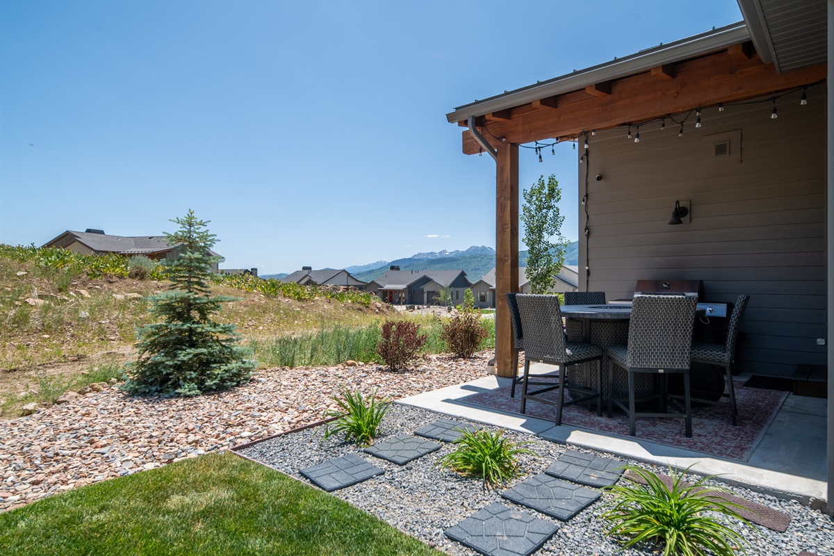 Covered outdoor dining patio with peaceful backyard setting