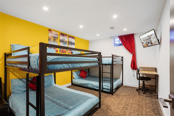 A space-saving design featuring a bunk bed, study table, and TV, perfectly blending sleep, work, and entertainment in one cozy room.