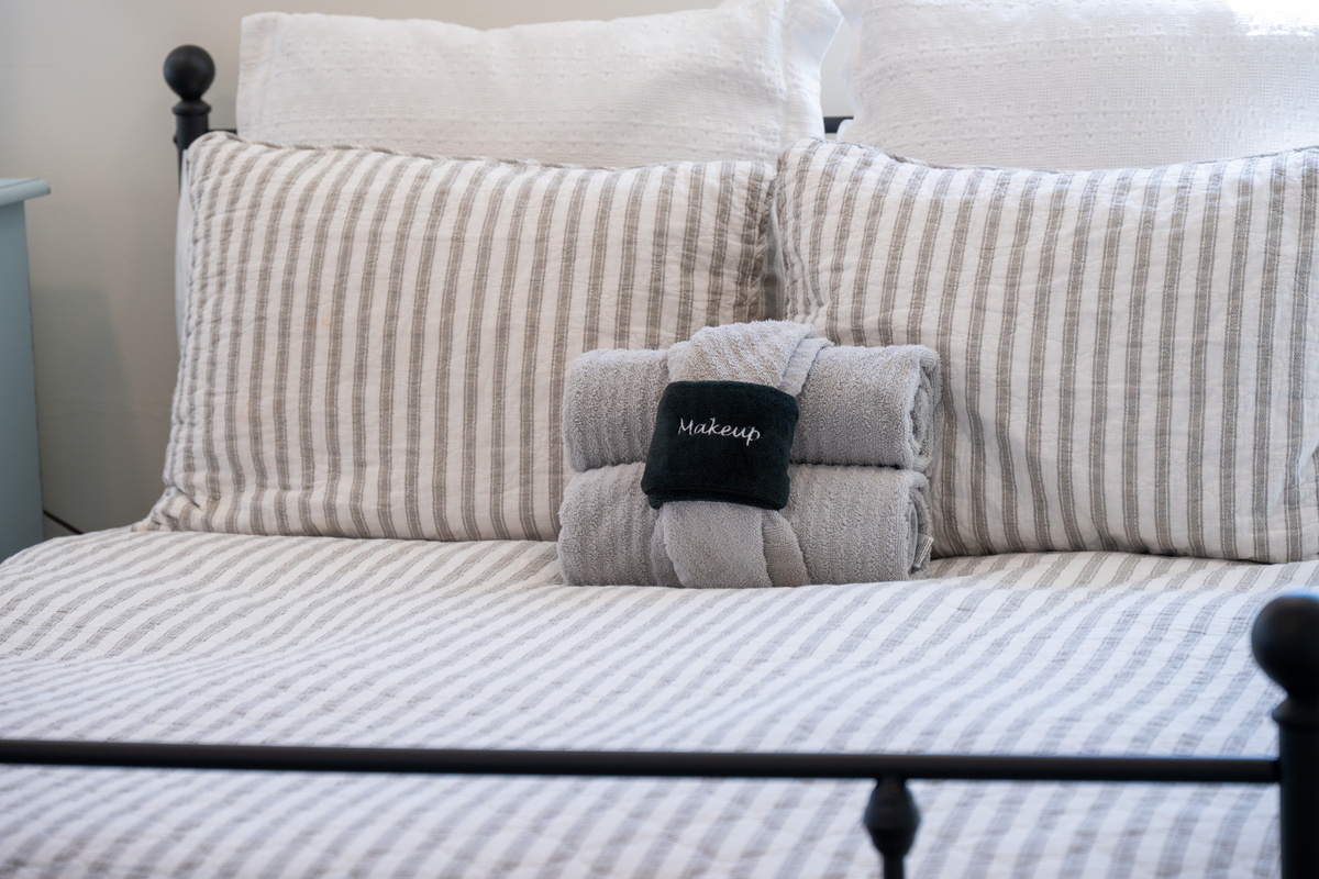 Soft neutral bedding and neatly arranged towels add a polished, welcoming touch, ensuring each guest will arrive to a beautifully prepared sleeping space.