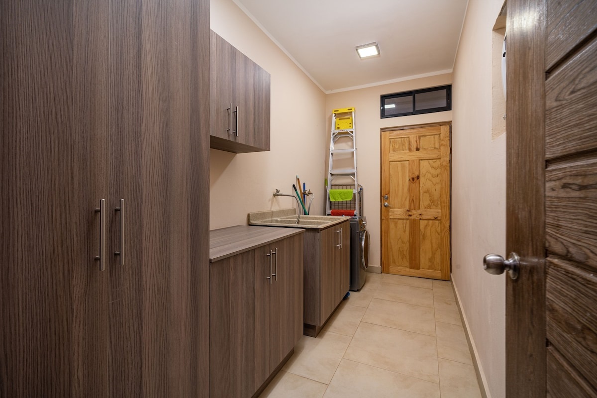 Laundry room with washer/dryer combo, scrub sink and cleaning supplies