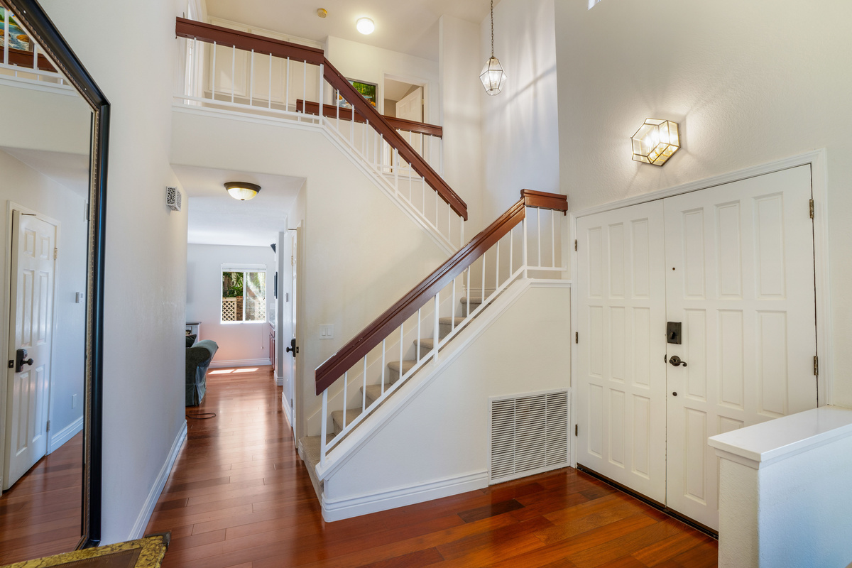 Welcoming Foyer with High Ceilings, Staircase & View into the Living Room