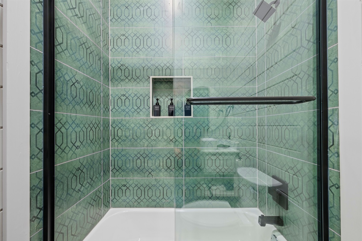 A glass shower door and beautiful tilework make this bathroom feel like a private spa tucked inside your own cabin getaway.