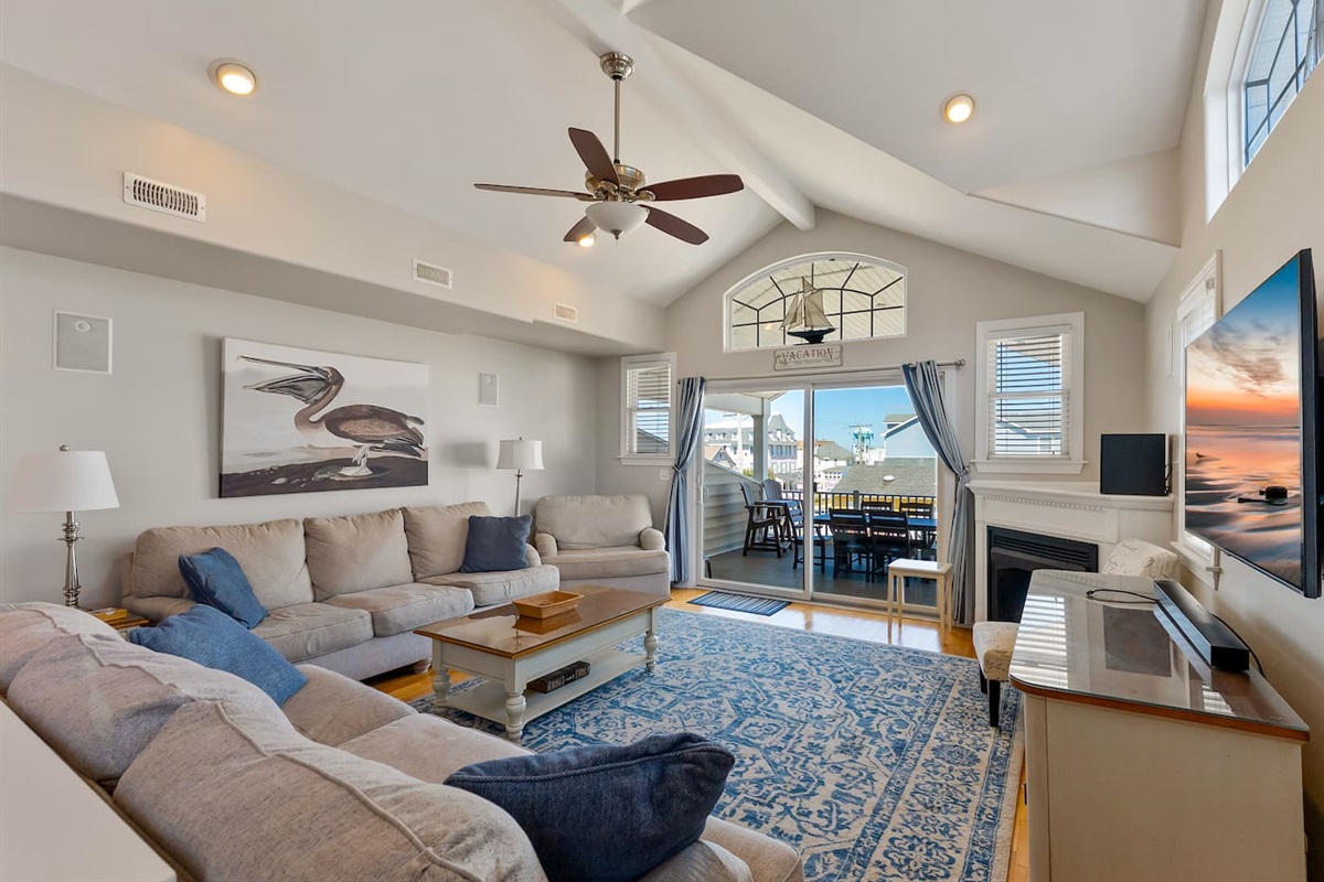 Spacious Living Room with fireplace, HDTV, and access to private balcony with views of the ocean.