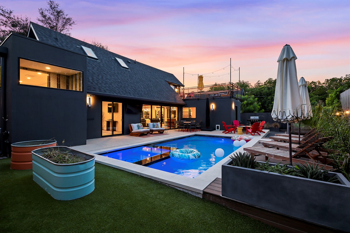  This stunning backyard is an entertainer's dream, centered around a sparkling, illuminated pool that creates a resort-like atmosphere.