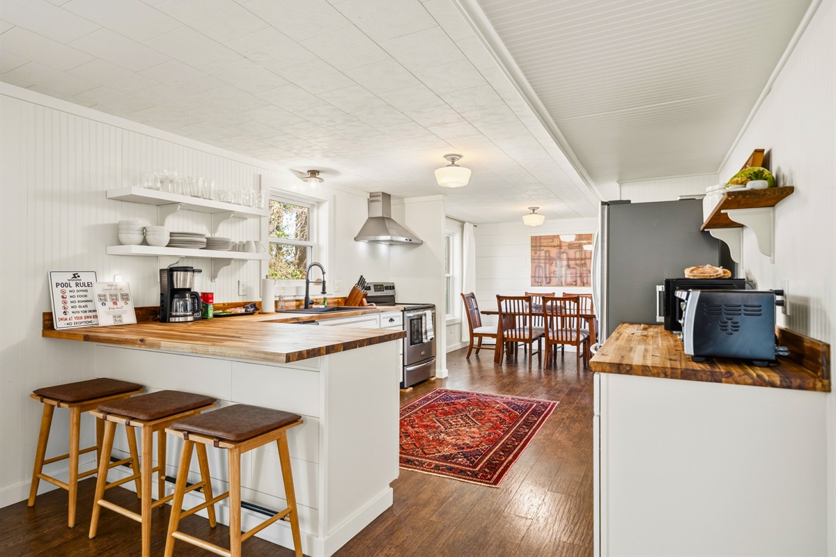 Gather around the kitchen area in the guest house where bar seating adds a casual, social element for meals, snacks, or morning coffee.