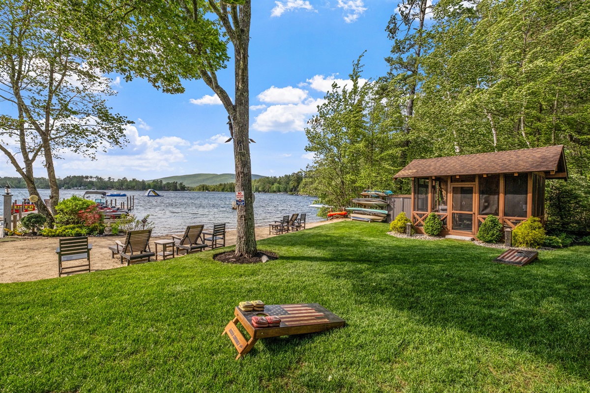 Backyard with ample amounts of yard games and outdoor screen gazebo